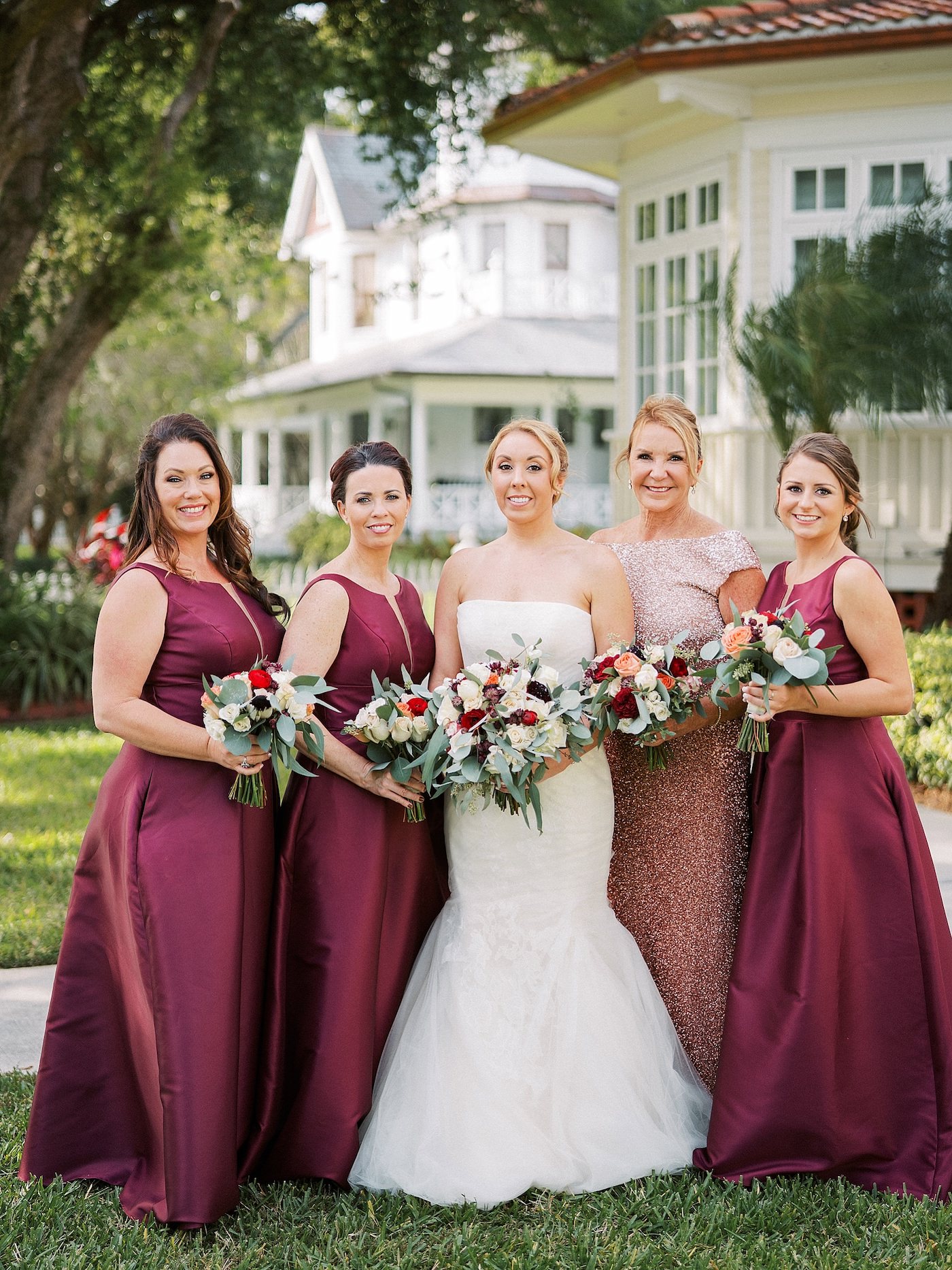 Strapless Ivory Tulle Rouched Mermaid Vera Wang Bridal Gown with Rhinestone Beaded Sash Waistband | Burgundy Wine Bordeaux Red and White Bouquets with Eucalyptus Greenery by Tampa Wedding Florist Brides N Blooms | Florida Fall Autumn Wedding Party Portrait with Deep Red Long Formal Bridesmaid Dresses and Gold Sequin Mother of the Bride Gown