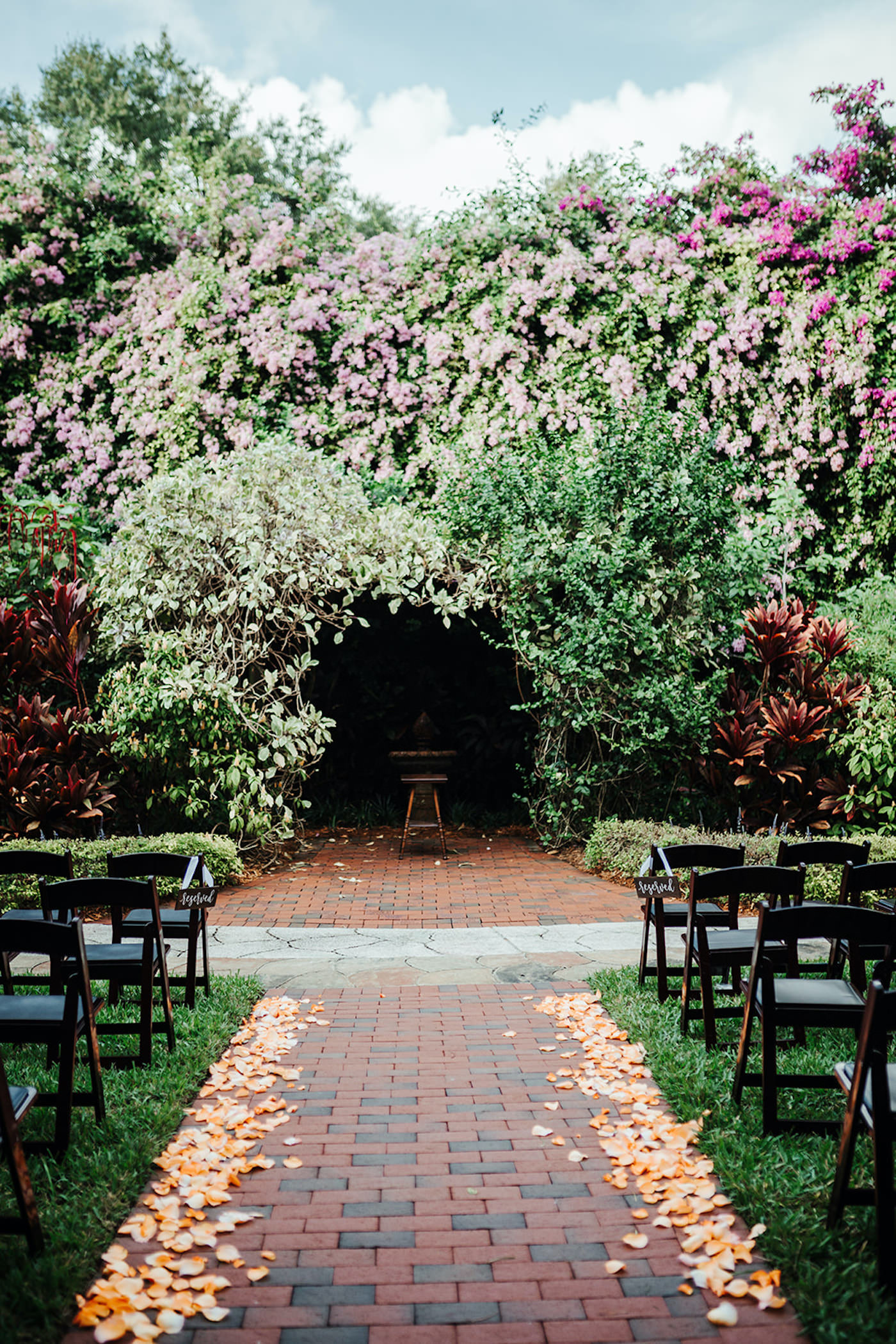 Whimsical Outdoor Wedding Ceremony Decor, Wooden Folding Chairs and Peach Rose Petals in Aisle, St. Petersburg Wedding Venue Sunken Gardens | Tampa Wedding Planner Kelly Kennedy Weddings and Events