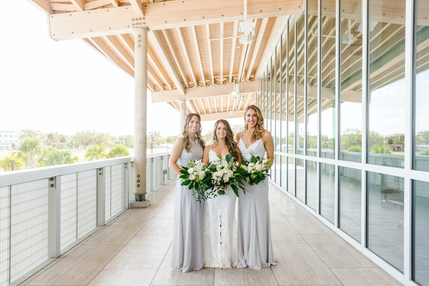 Tampa Wedding Florist Bruce Wayne Florals | Bride and Bridesmaids Portrait Shot | Light Grey Silver Neutral Long Bridesmaid Dresses with Tropical White and Green Bouquets