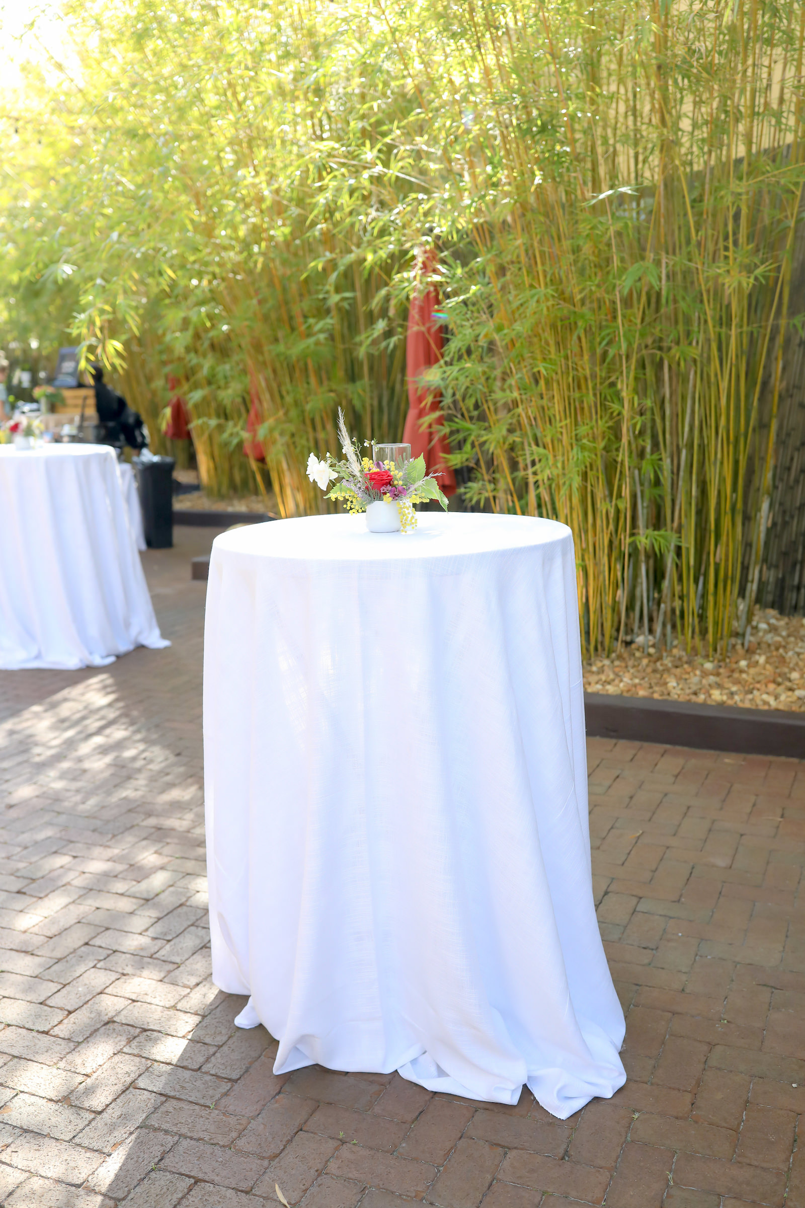 Tall Cocktail Table with White Linen Low Floral and Greenery Centerpiece | St. Pete Unique Wedding Venue Bamboo Courtyard NOVA 535 | Monarch Events and Design