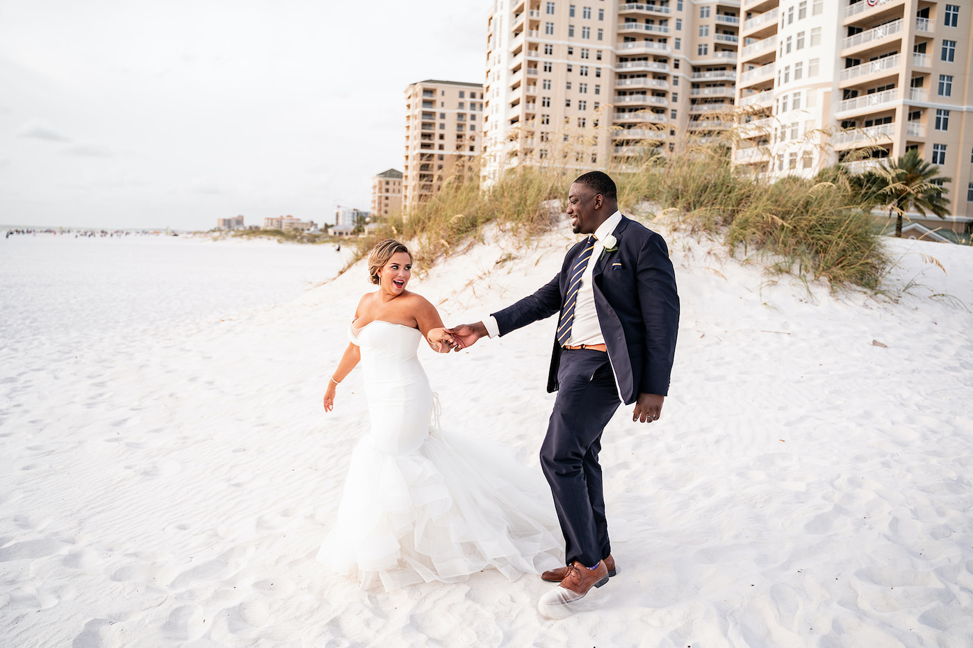 Tampa Bay Bride and Groom Beachfront Wedding Portraits, Romantic Tropical Bride and Groom Just Married on the sand of Clearwater Beach, Bride Wearing Sophisticated Fit and Flare Strapless Wedding Dress | Florida Gulf of Mexico Hotel and Wedding Venue Hilton Clearwater Beach