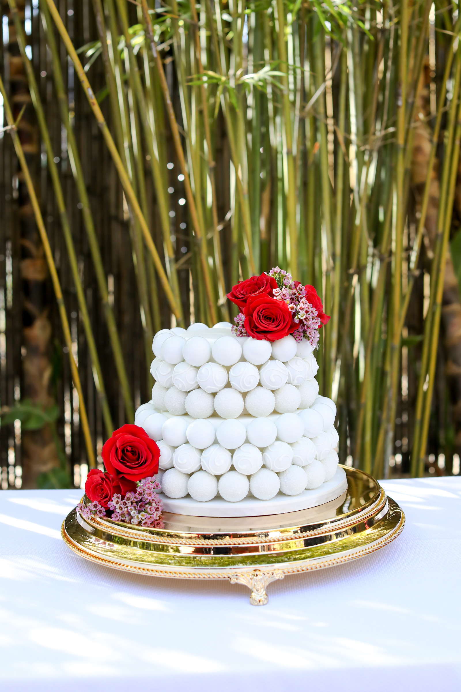 White Two Tier Cake Pop Cake Garnished with Red Roses and Pink Flowers | Tampa Bay Cake Company