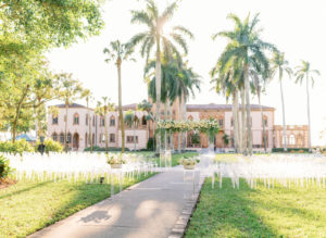 Romantic, Modern Florida Outdoor Wedding Ceremony with Jewish Wedding Altar, Ghost Chairs, Clear Acrylic Chuppah with Lush Ivory Floral Bouquets and Greenery, In Courtyard of The Ringling Museum | Sarasota Wedding Planner NK Weddings