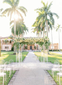 Romantic, Modern Florida Outdoor Wedding Ceremony with Jewish Wedding Altar, Ghost Chairs, Clear Acrylic Chuppah with Lush Ivory Floral Bouquets and Greenery, In Courtyard of The Ringling Museum | Sarasota Wedding Planner NK Weddings