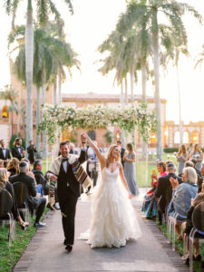 Romantic, Modern Florida Bride and Groom Just Married Recessional, Outdoor Wedding Ceremony with Jewish Altar, Ghost Chairs, Clear Acrylic Chuppah with Lush Ivory Floral Bouquets and Greenery Decor, In Courtyard of The Ringling Museum | Sarasota Wedding Planner NK Weddings