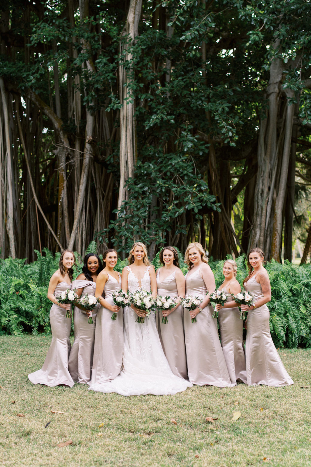 Modern Day Fairytale Florida Bridal Party, Bride Wearing Galia Lahav Wedding Dress Holding White Floral and Ivory Rose Bouquet with Greenery, Bridesmaids in Blush Satin Hayley Paige Occasions Long Mix and Match Dresses | Tampa Dress Shop Isabel O’Neil Bridal | Sarasota Hair and Makeup by Femme Akoi Beauty Studios | Sarasota Wedding Planner NK Weddings | Tampa Bay Bridesmaid Dress Shop Bella Bridesmaids Tampa