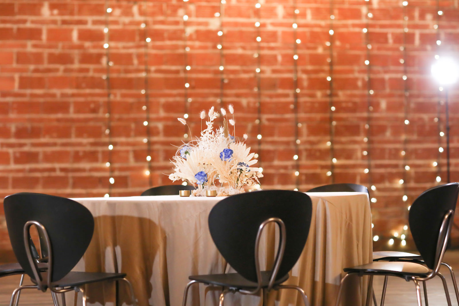 Whimsical Boho Wedding Reception Decor, Round Table with Ivory Linen, Pampas Grass and White Feather with Blue Floral Centerpiece | NOVA 535 | Over the Top Rental Linens | John Campbell Weddings