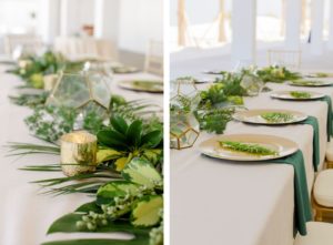Clearwater Beach Wedding Venue Hilton Clearwater Beach | Modern Tropical Beach Outdoor Wedding Reception Terrace Feasting Table with Champagne Table Linens and Emerald Green Napkins under Gold Charger Plates topped with Ferns | Gold Chiavari Chairs and Tropical Palm Frond Leaf Floral Arrangement Garland and Gold Geometric Candles