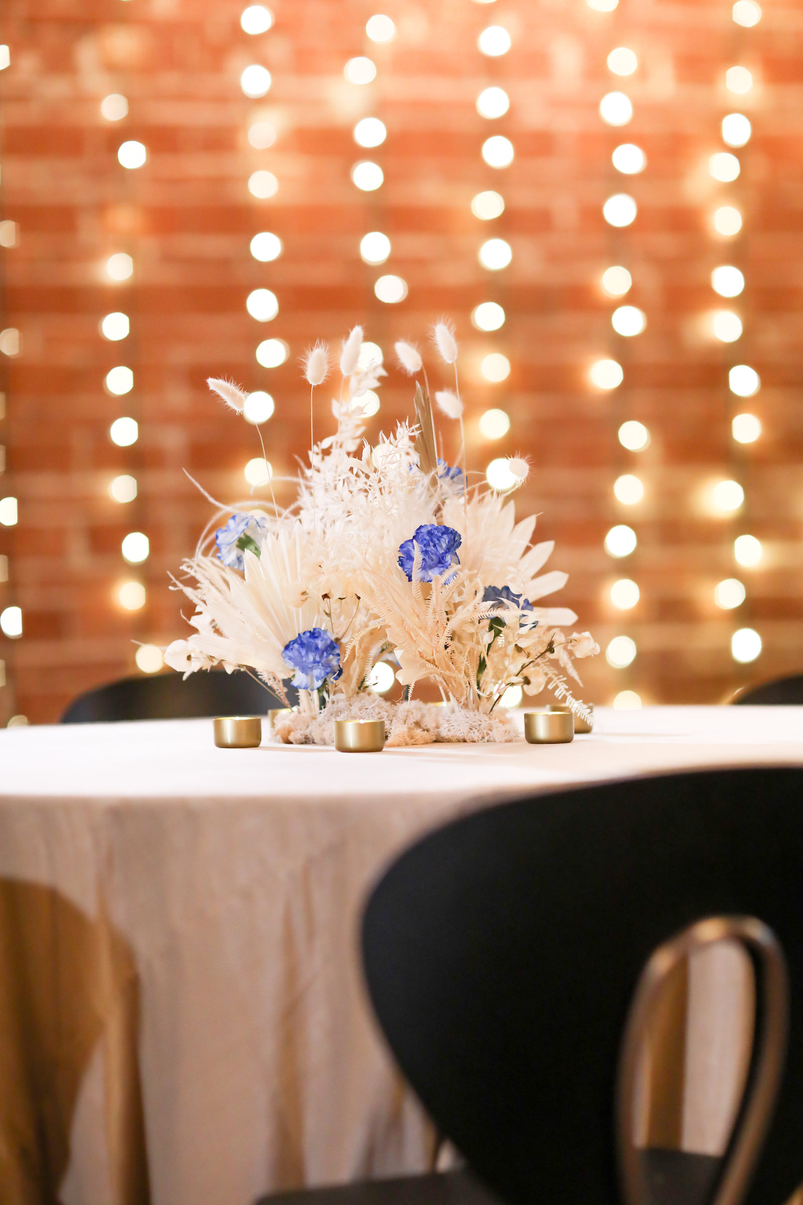 Whimsical Boho Wedding Reception Decor, Round Table with Ivory Linen, Pampas Grass and White Feather with Blue Floral Centerpiece | NOVA 535 | Over the Top Rental Linens | John Campbell Weddings