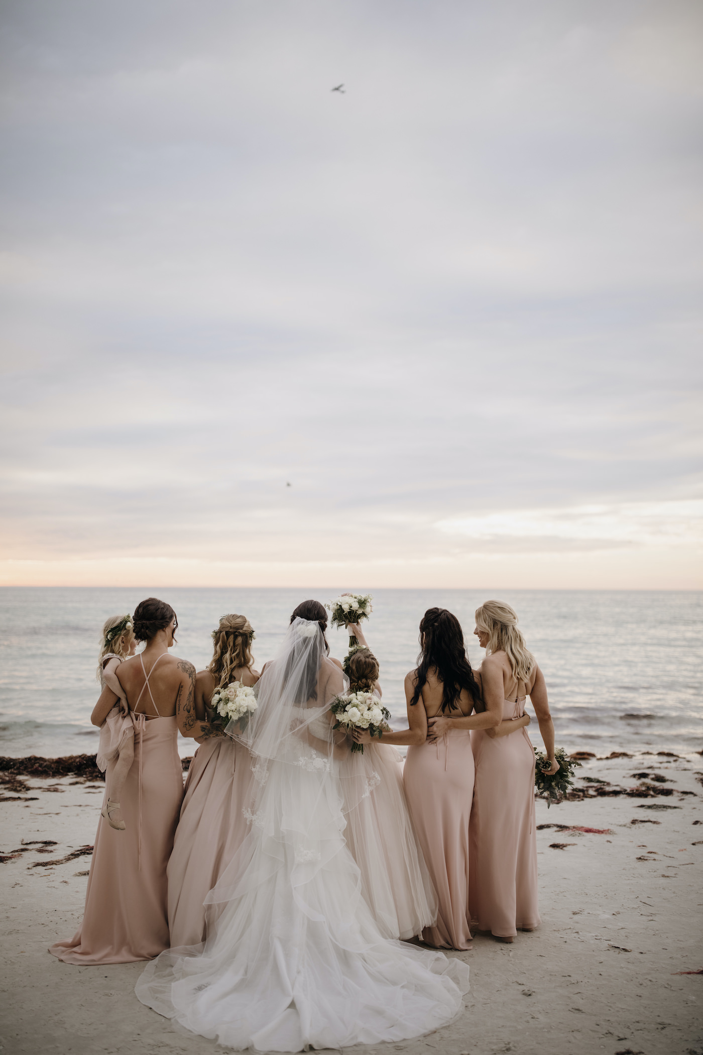 Bride and Bridesmaids Outdoor Beach Portrait Shot | Bridesmaids in Blush Pink Long Chiffon Dresses | Blush Pink and White Bridesmaids Bouquets with Greenery