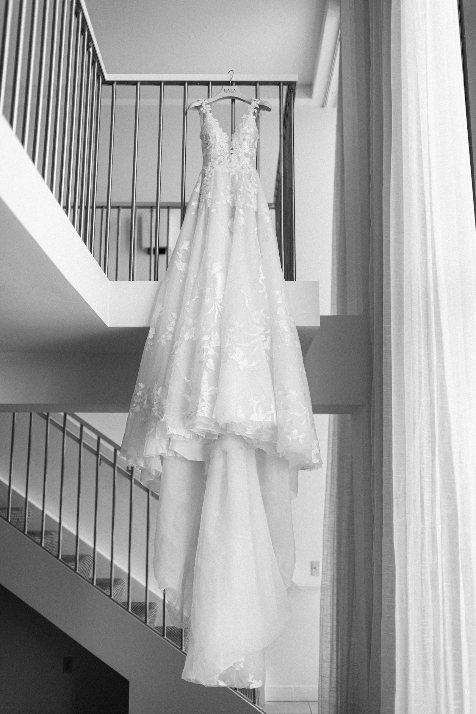 Romantic, Fairytale inspired wedding dress hanging from staircase, Galia Lahav Modern Bridal Dress | Florida Luxury Wedding and Dress Boutique Isabel O’Neil Bridal