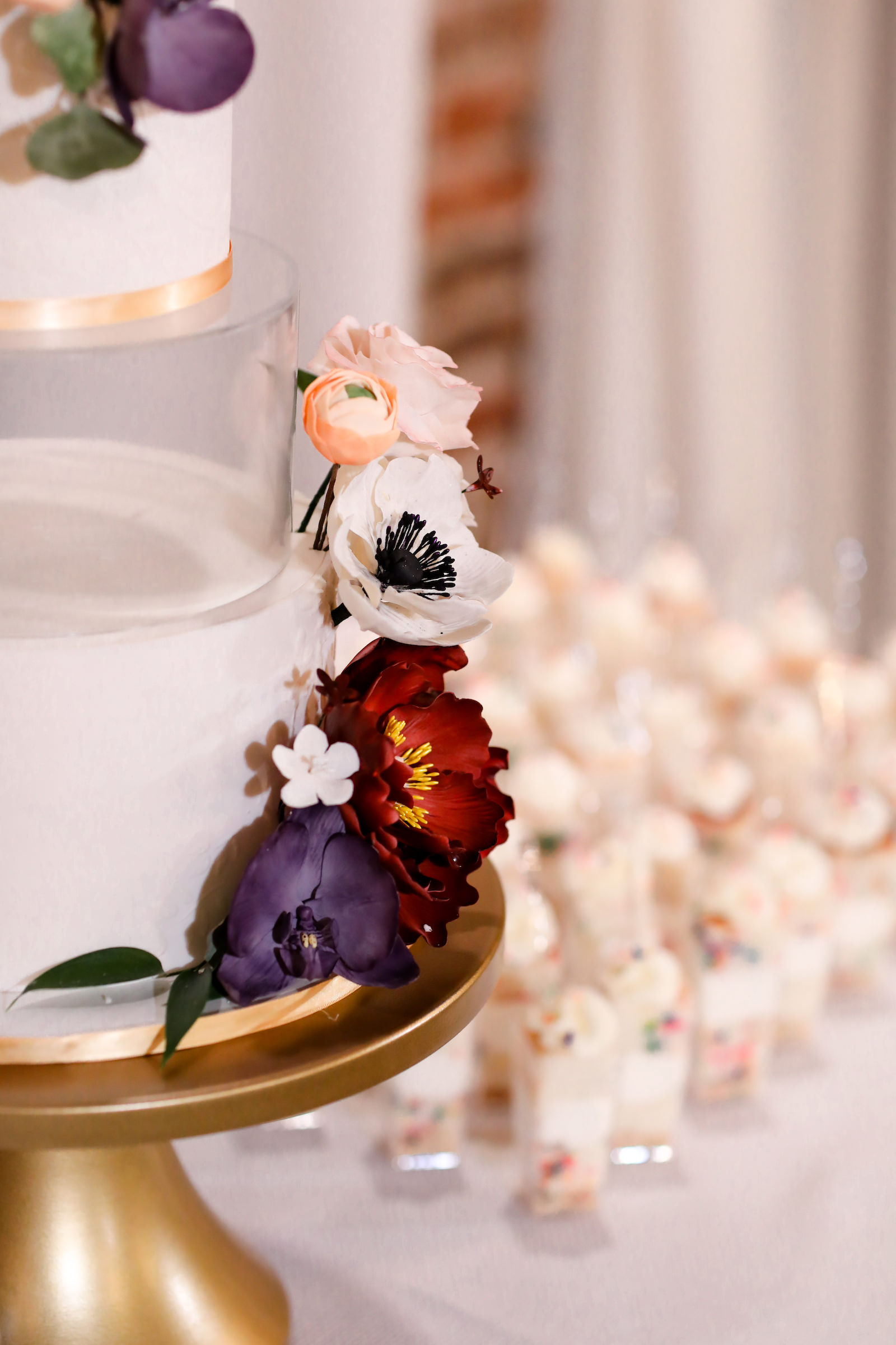 Modern Four Tiered Round White and Gold Wedding Cake with Red, Purple and White Anemone Sugar Flowers | Individual Confetti Cake Cups | Tampa Bay Cake Company