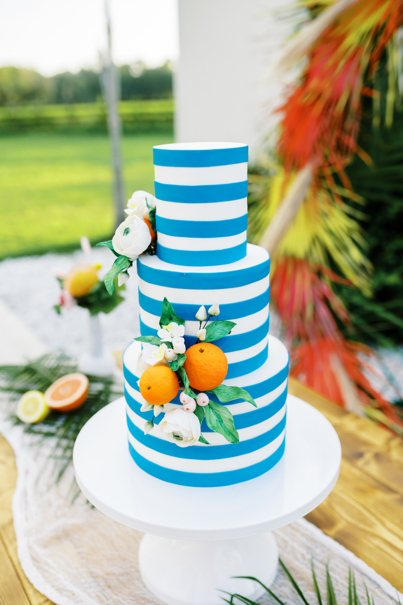 Wood Farm Table Wedding Cake Display | Three Tier Blue and White Stripe Wedding Cake with Fresh Citrus by Tampa Bay Cake Company Bakery | Tropical Florida Citrus Wedding Inspiration