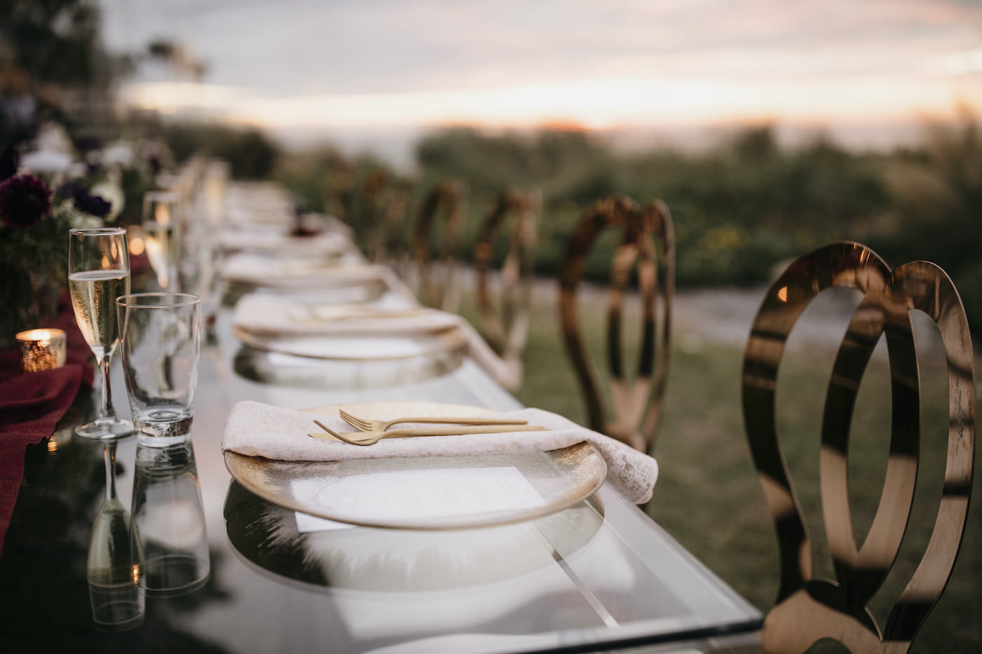 Outdoor Sarasota Beach Neutral Gold and Champagne Wedding Reception Table with Gold Glass Charger Plates and Gold Flatware and Gold King Louis Chairs