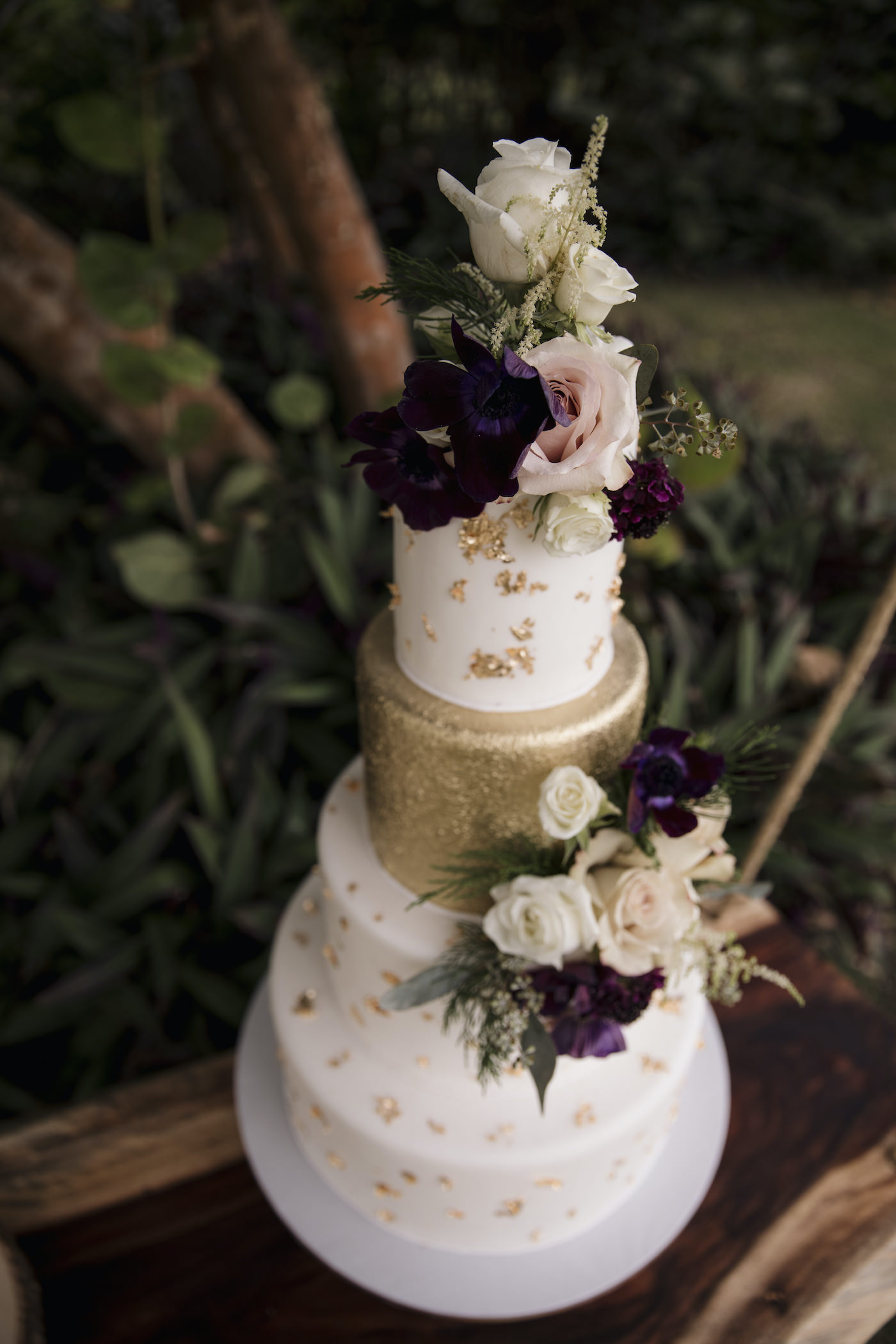 Four Tier Wedding Cake with Gold Leaf and Fresh Flowers | Deep Red Maroon Purple and Blush Pink Anemone with White Roses and Astilbe and Greenery Cake Topper