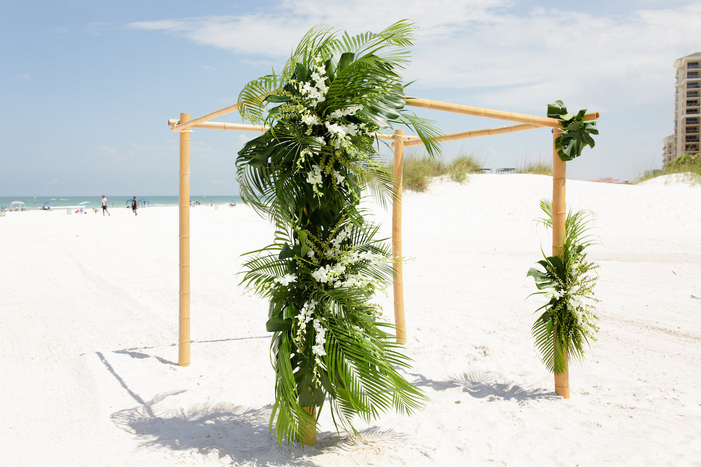 Clearwater Beach Wedding Venue Hilton Clearwater Beach | Modern Tropical Beach Wedding Ceremony with Tropical Palm Frond Leaf and Orchid Floral Arrangements on Bamboo Arch