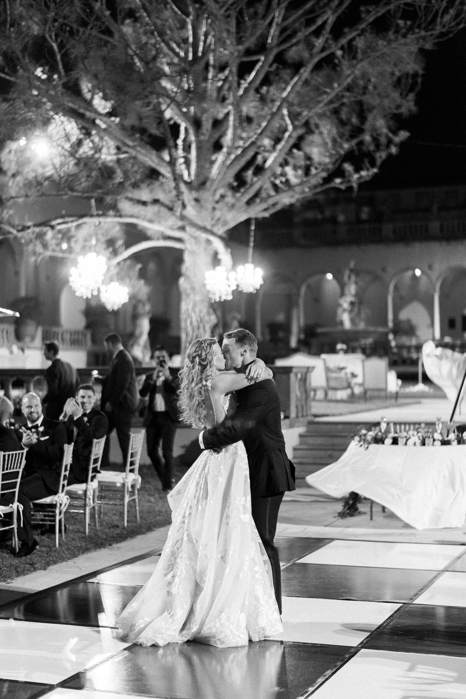 Sarasota Bride and Groom Kiss During First Dance During Outdoor Reception at The Museum of Art at the Ringling, On Black and White Dance Floor | Florida Wedding Planner NK Weddings