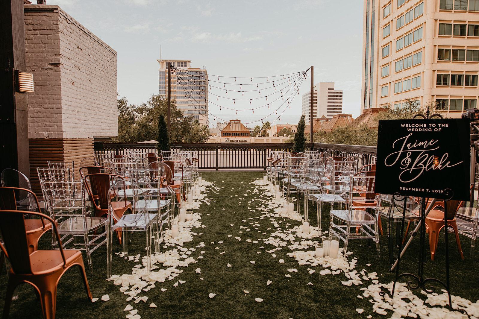 Modern Rooftop Wedding Ceremony with City Skyline and Mismatched Clear Acrylic Chairs and Industrial Copper Chairs | Unique, Historic Downtown St. Pete Wedding Venue Station House | St. Petersburg Wedding Planner Blue Skies Events