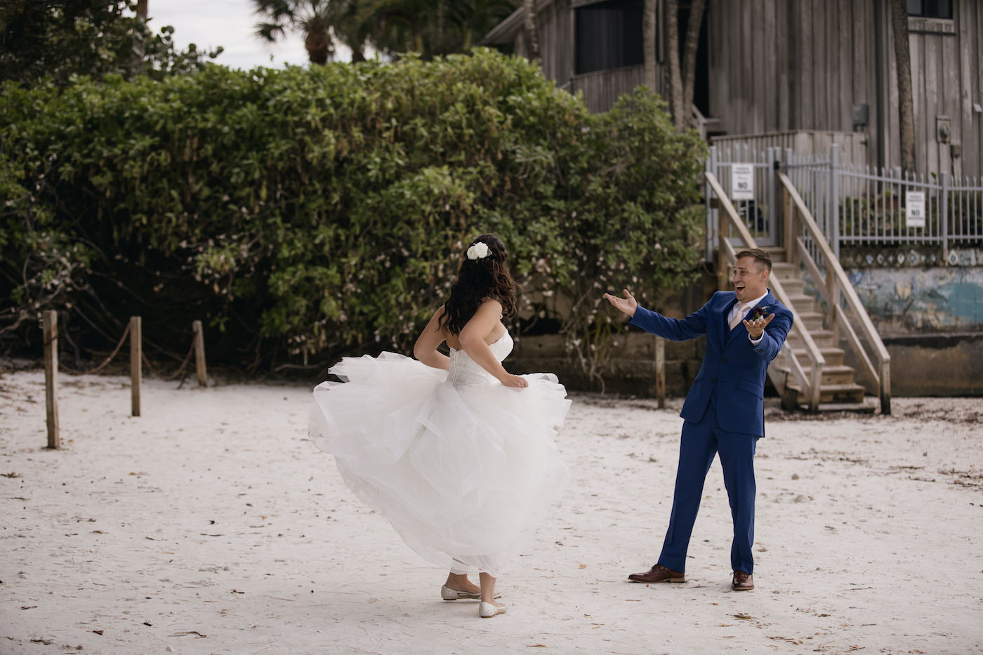 Outdoor Bride and Groom Portrait | Bride and Groom First Look Sarasota Beach Wedding | Groom in Navy Blue Suit with Blush Pink Neck Tie | Bride Twirling in Tulle Organza Ballgown