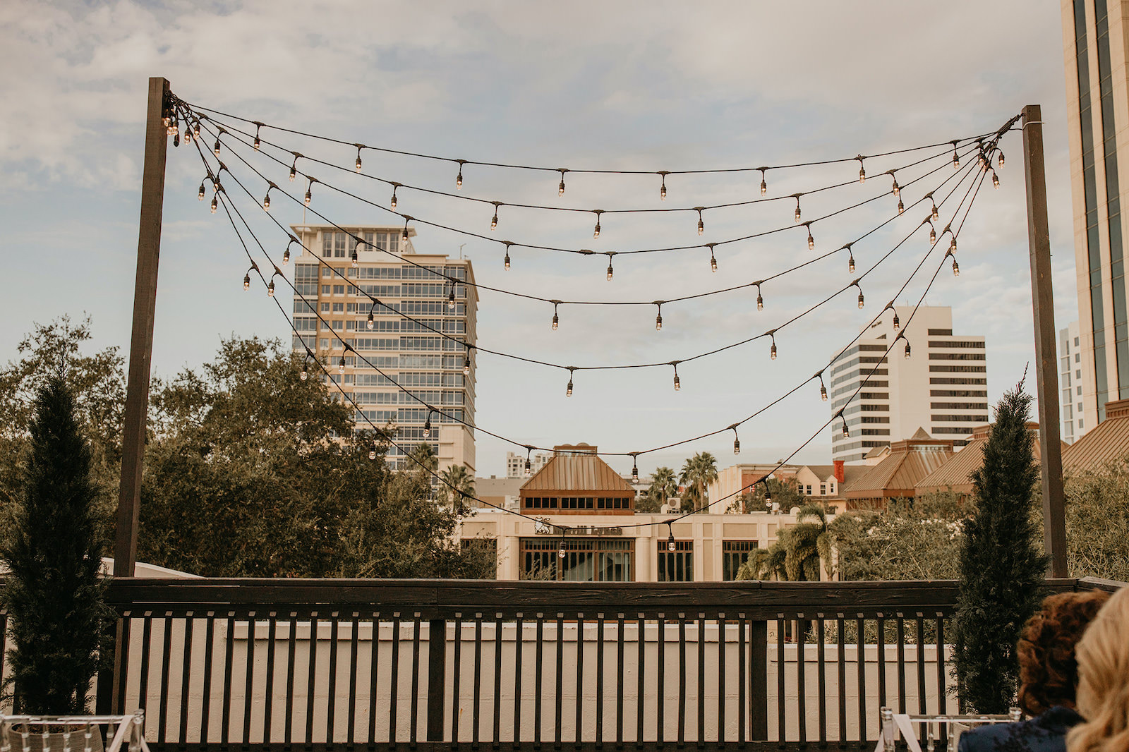 Modern Rooftop Wedding Ceremony with City Skyline and Mismatched Market String Lights | Unique, Historic Downtown St. Pete Wedding Venue Station House