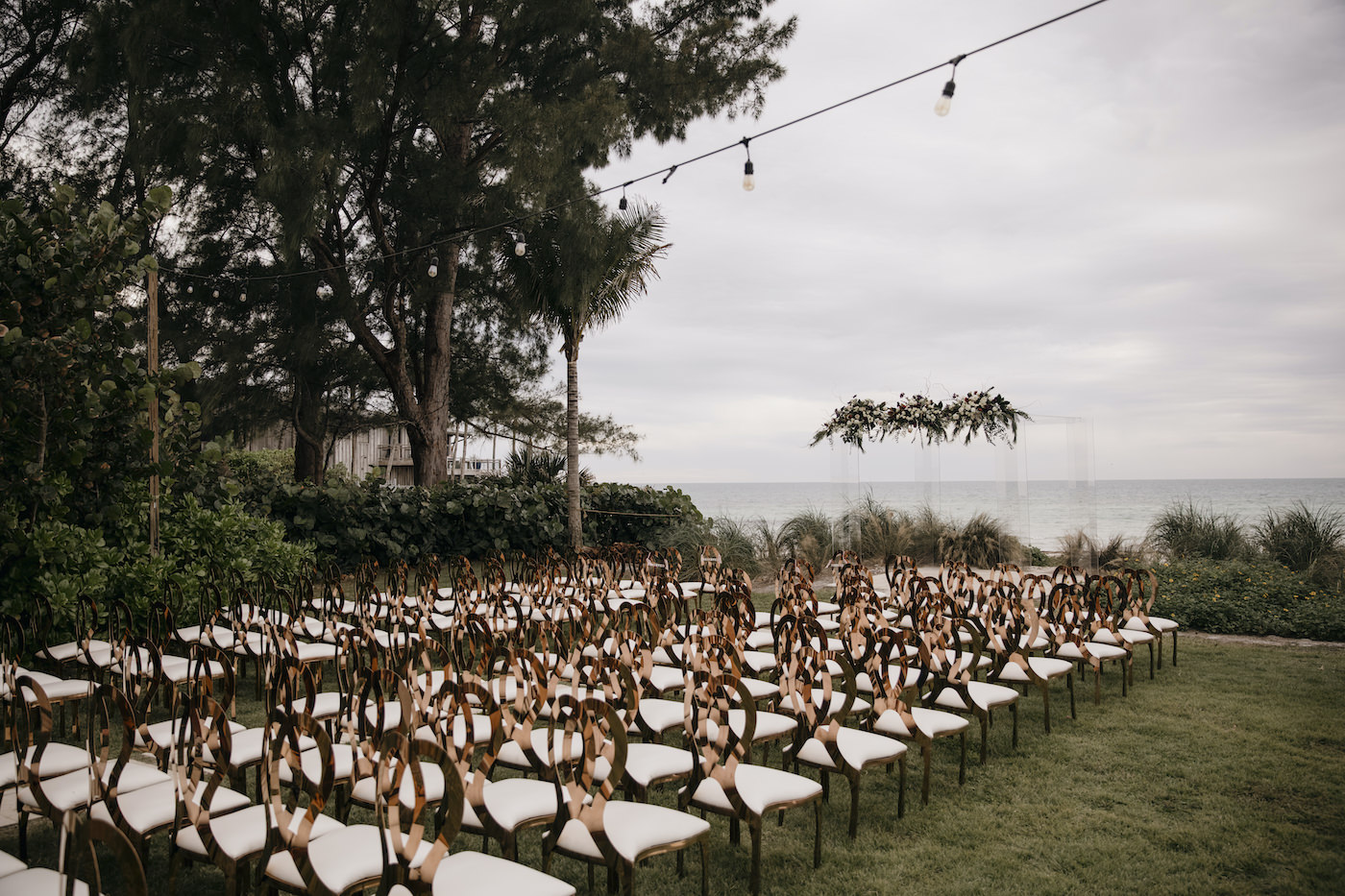 Sarasota Outdoor Beach Wedding Ceremony on Siesta Key | Acrylic Four Post Arbor Backdrop | Gold King Louis Chairs