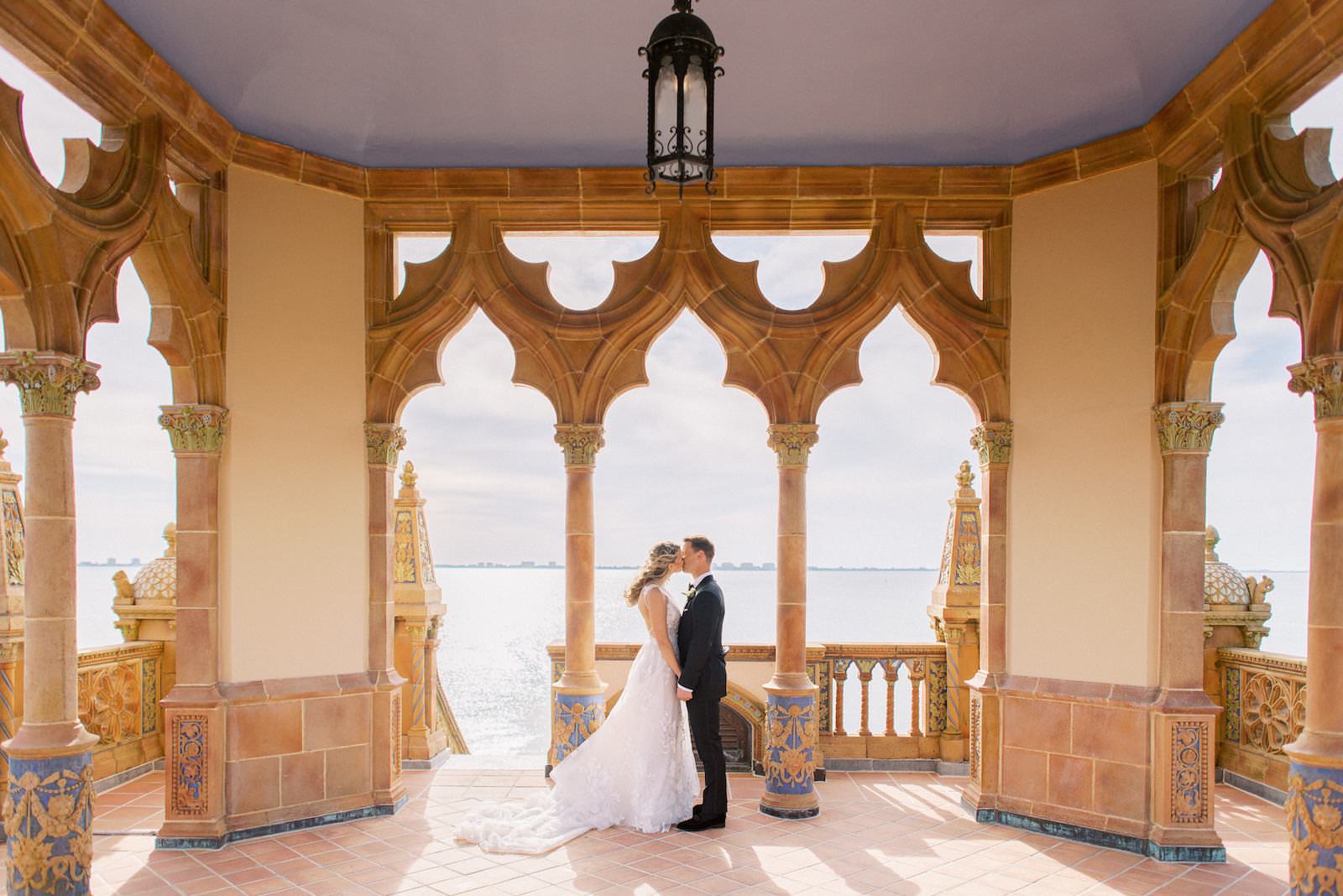 Florida Bride and Groom Intimate Embrace at The Ringling Museum Waterfront Belvedere Tower at the Ca’ d’Zan | Sarasota Wedding Planner NK Weddings