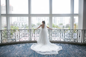 Indoor Downtown Tampa Hotel Window Bridal Portrait at Marriott Water Street | V Neck Illusion Lace A Line Ballgown Wedding Dress with Rhinestone Waist Band and Cathedral Veil