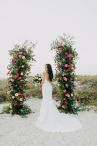 Spaghetti Strap Casablanca Ivory Simple Slip Wedding Dress Bridal Gown | Blush Pink and Fuchsia Roses and Greenery Wedding Ceremony Backdrop Arrangements | Bride and Groom and Son at Tampa St Pete Florida COVID Destination Elopement Beach Wedding Ceremony | Amber McWhorter Photography