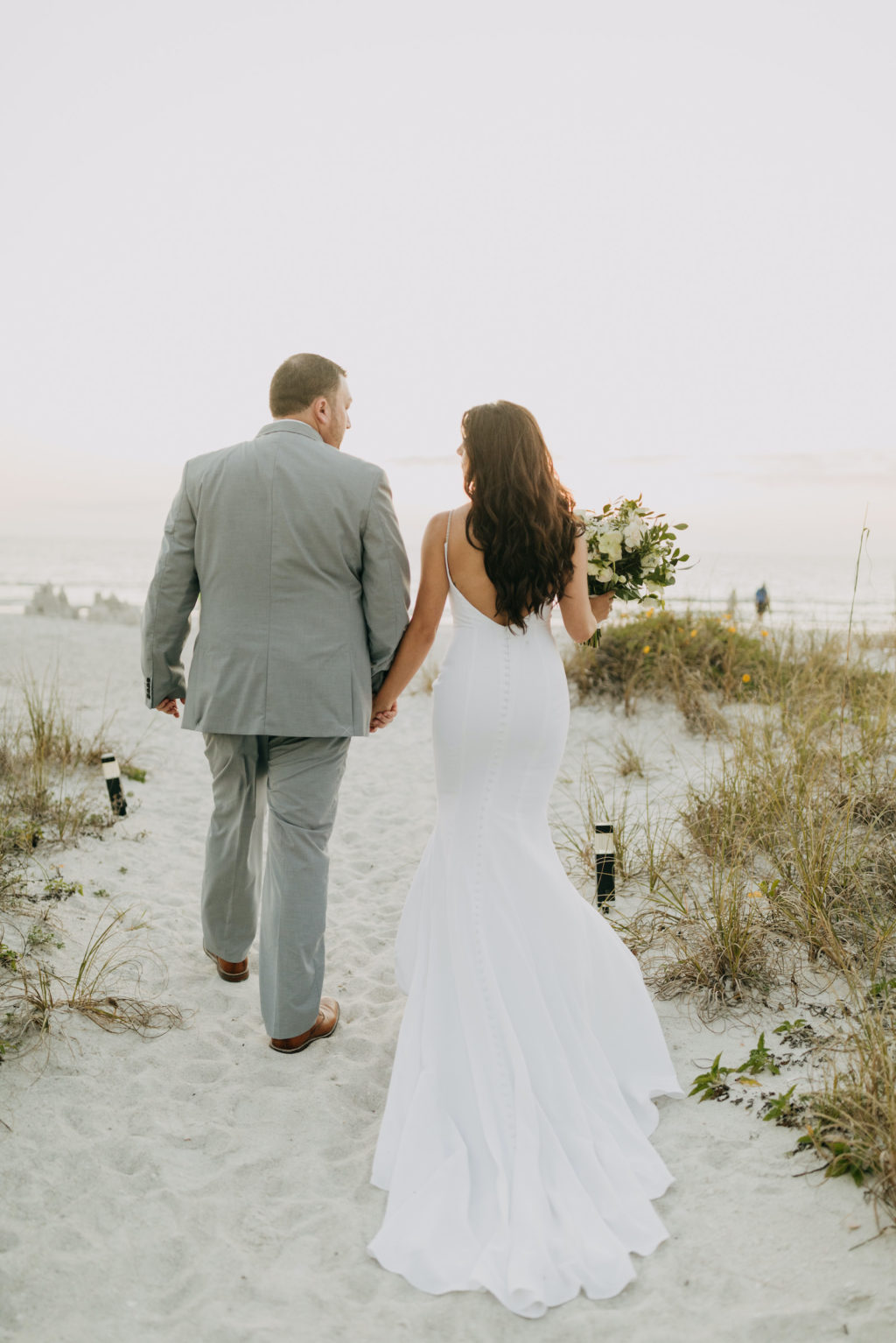 Spaghetti Strap Casablanca Ivory Simple Slip Wedding Dress Bridal Gown | Light Blue Grey Groom Suit | Outdoor Bride and Groom Beach Portrait at Tampa St Pete Florida COVID Destination Elopement Beach Wedding Ceremony | Amber McWhorter Photography