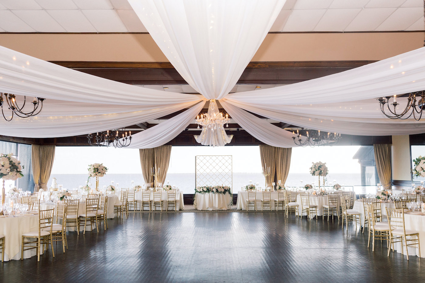 Classic Elegant Wedding Reception Decor, White Ceiling Draping, Chandeliers, Gold Chiavari Chairs, Low and Tall Floral Centerpieces | Tampa Bay Wedding Planner Special Moments Event Planning | Tampa Bay Wedding Reception Venue The Rusty Pelican
