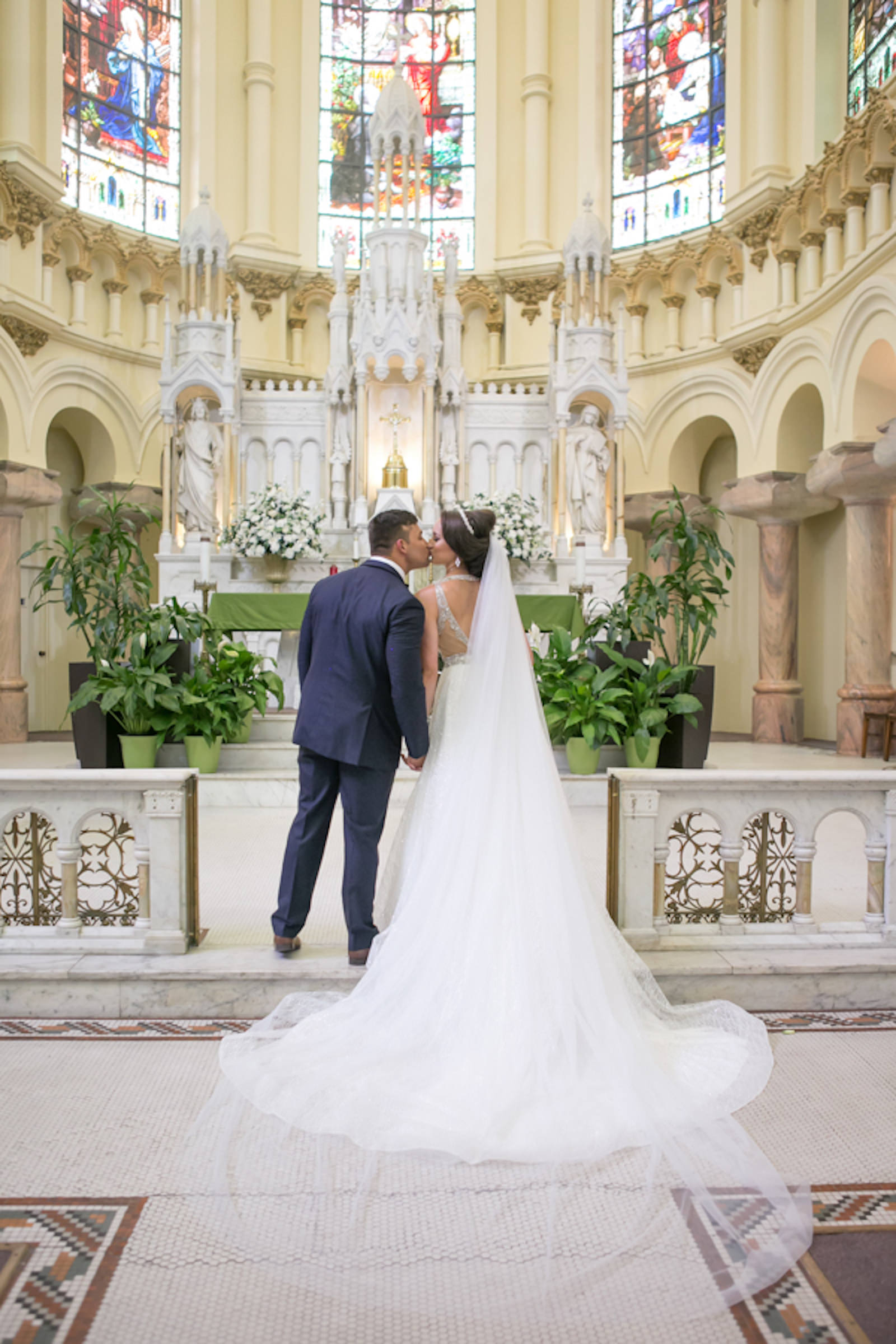 Indoor Downtown Tampa Bride and Groom Portrait at Traditional Catholic Ceremony Cathedral Church | V Neck Illusion Lace A Line Ballgown Wedding Dress with Rhinestone Waist Band and Cathedral Veil | Carrie Wildes Photography