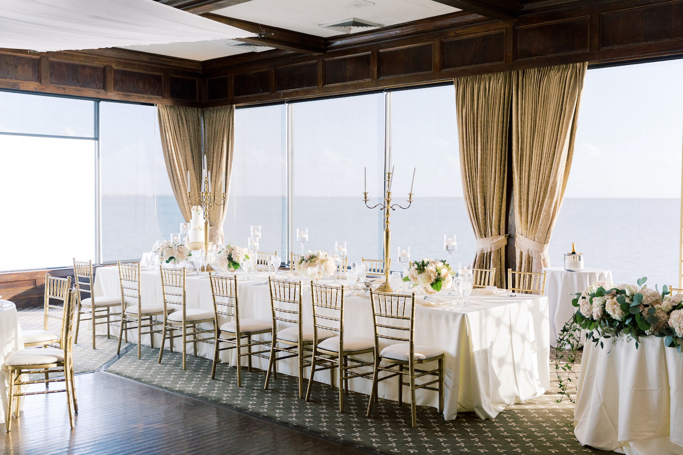Classic Romantic Wedding Reception Decor, Long Feasting Table with White Linen, Gold Chiavari Chairs, Tall Gold Candelabras | Tampa Bay Wedding Florist, Candelabra Rentals Gabro Event Services | Tampa Bay Wedding Venue The Rusty Pelican