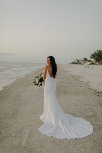 Spaghetti Strap Casablanca Ivory Simple Slip Wedding Dress Bridal Gown | Outdoor Bride and Groom Beach Portrait at Tampa St Pete Florida COVID Destination Elopement Beach Wedding Ceremony | Neutral White Ivory and Greenery Bridal Bouquet | Amber McWhorter Photography