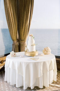 Classic Three Tier White Wedding Cake with Flowers on Gold Cake Stand | Tampa Bay Wedding Florist Gabro Event Services | Waterfront Wedding Reception Venue Tampa Bay The Rusty Pelican