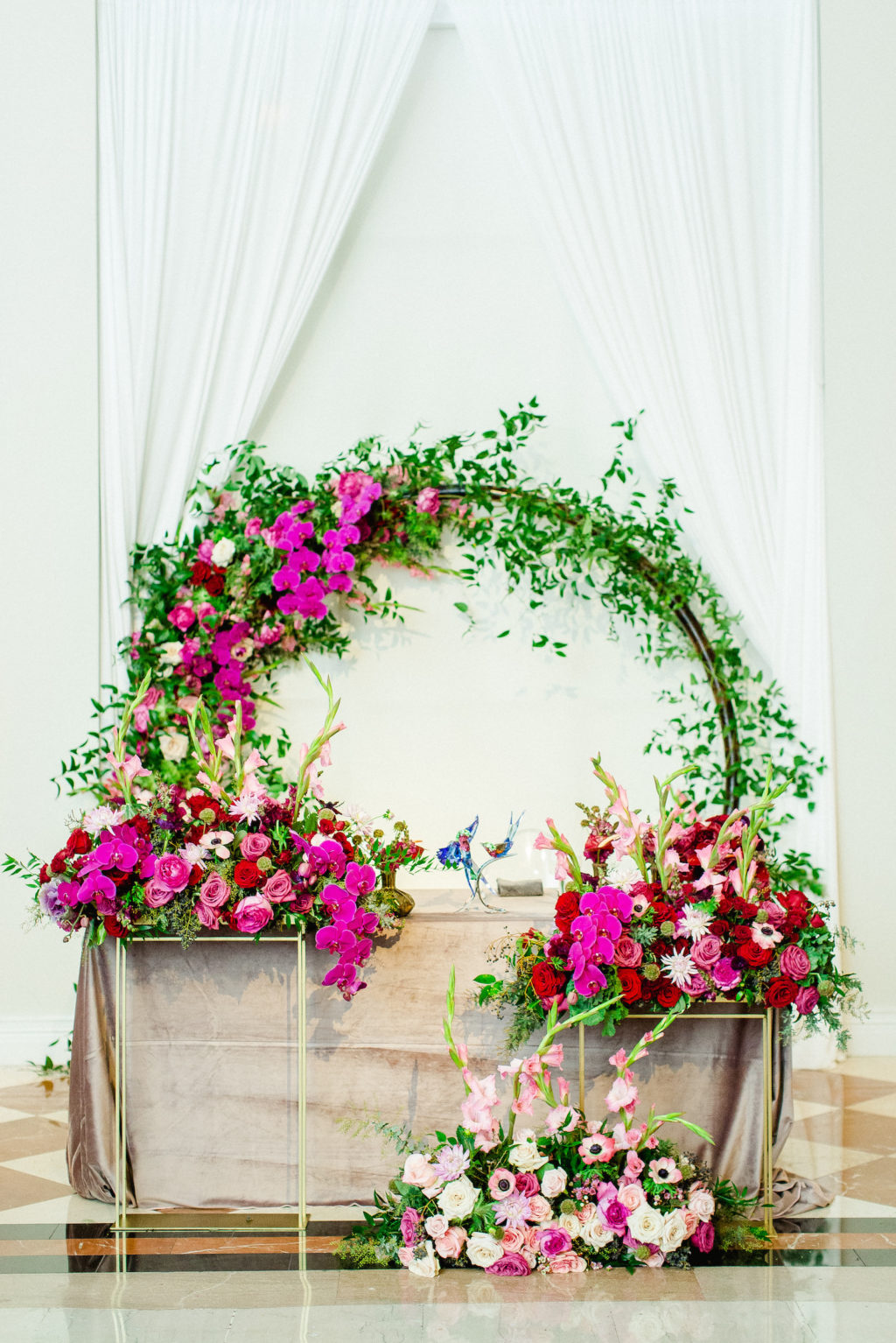 Downtown Tampa Colorful Luxury Wedding Sweetheart Table with Repurposed Aisle Flowers | Bright Colorful Floral Circle Moon Round Arch Backdrop with Pink Roses and Purple Orchids and Greenery