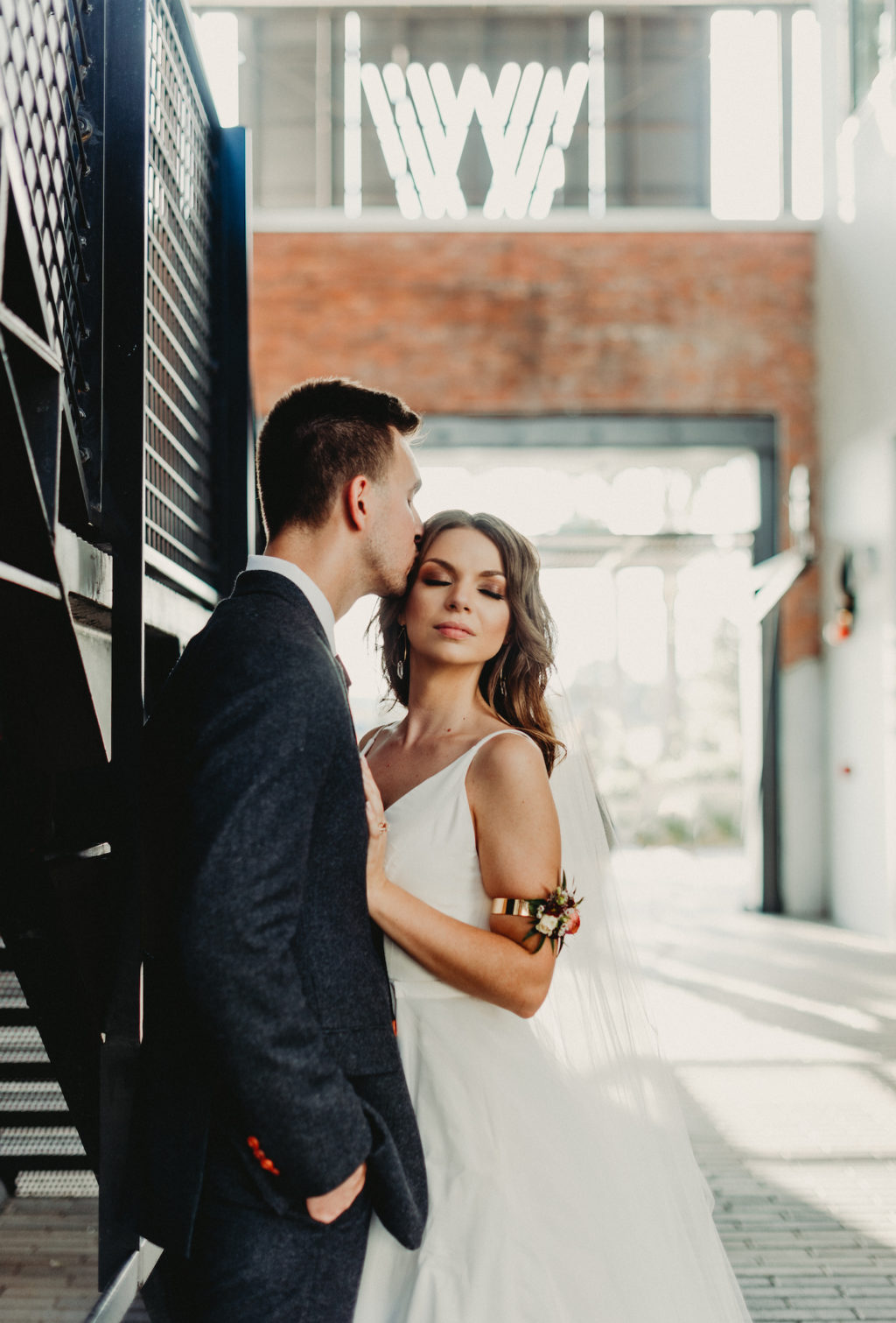 Bride and Groom Outdoor Wedding Portrait at Armature Works | Charcoal Grey Wool Groom Suit with Burgundy Maroon Red Neck Tie | Floral Bridal Arm Band | Dewitt for Love Photography
