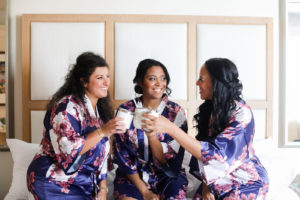 Florida Bride and Bridesmaids Cheers and Getting Ready, Wearing Matching Silk Navy Floral Robes | Florida Wedding Photographer Lifelong Photography Studio