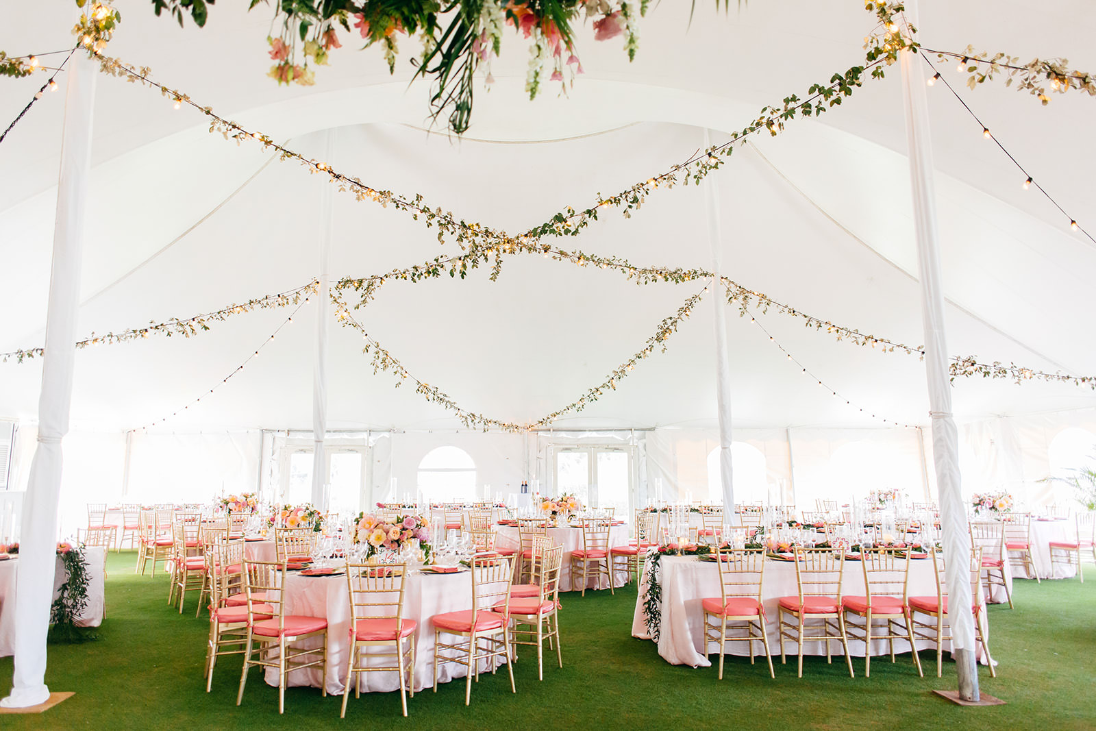 Elegant Tropical Tent Wedding Reception Decor, Tables with White Linens, Gold Chiavari Chairs with Pink Cushions, Hanging Floral Draping | Tampa Bay Wedding Planner NK Weddings