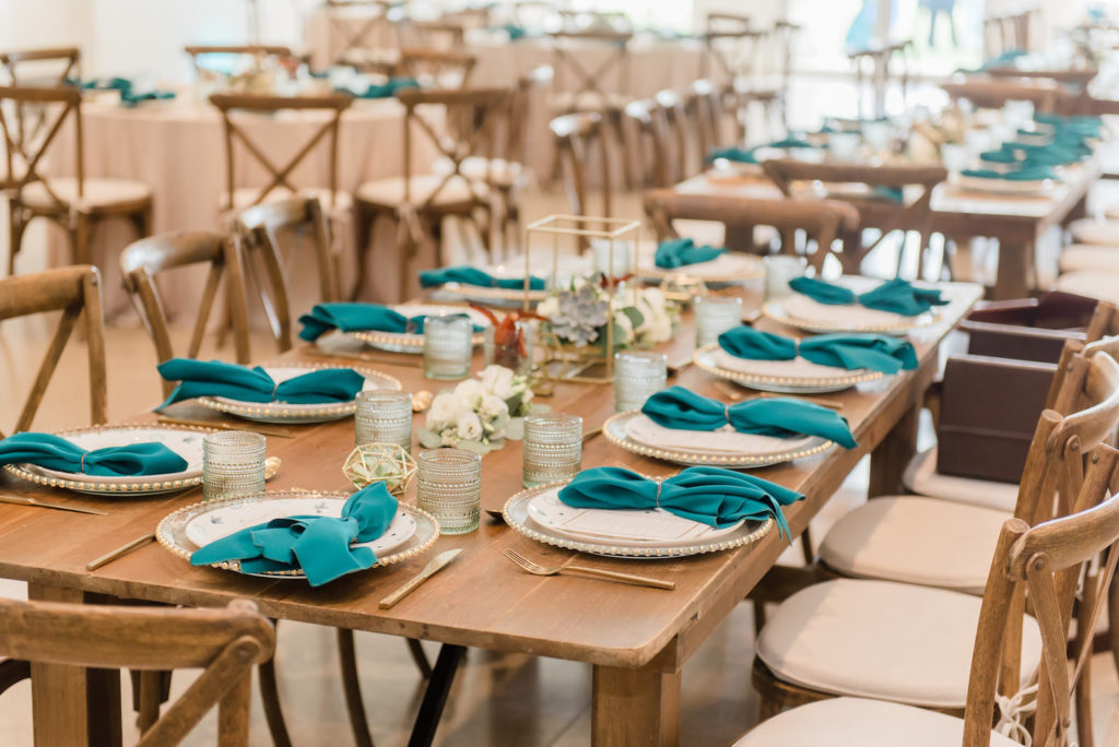 South Tampa Brunch Wedding with Bacon Bouquets | Rustic Wood Farm Feasting Tables with Cross Back Chairs | Gold Glass Beaded Edge Chargers with Fortessa Plates, Gold Flatware, Aqua Cups and Teal Turquoise Napkins | Winsor Event Studio