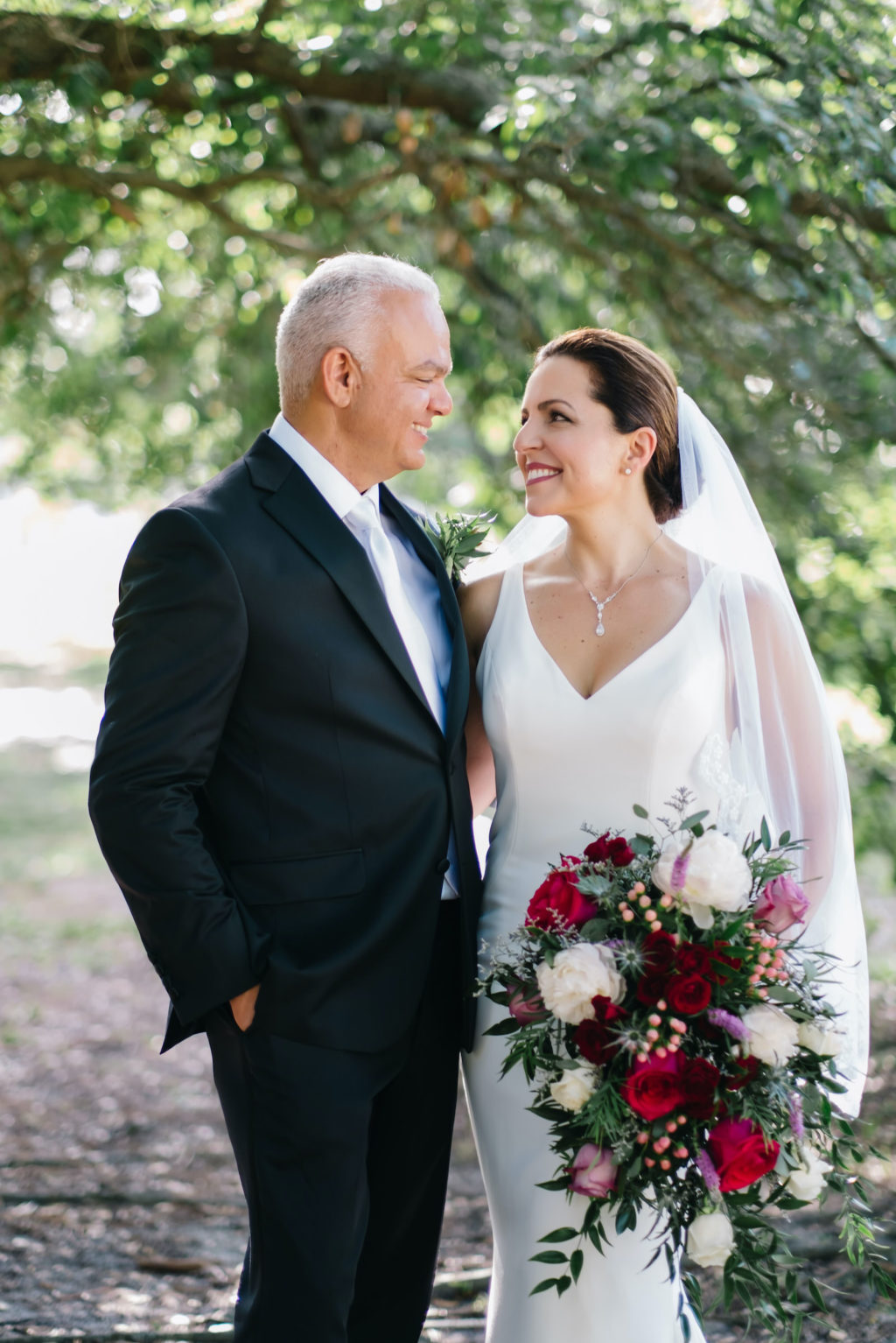 Sophisticated, Tampa Bay Bride, and Groom, Holding Vibrant Jewel Toned Floral Bouquet with Bright Pink Roses, Ivory, Purple, and Blue Flowers | Florida Wedding Planner Breezin' Weddings | South Tampa Outside The Box Event Rentals