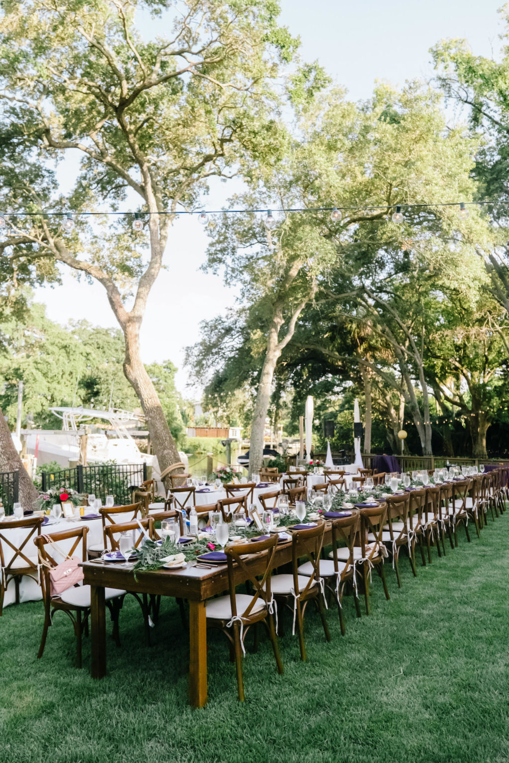 Romantic Outdoor Backyard Reception, Long Wooden Feasting Tables with Farmhouse Chairs, Purple Linens | South Tampa Wedding Planner Breezin' Weddings | Beach Park Wedding Rentals Outside the Box Event Rentals | Tampa Bay Wedding DJ Breezin' Entertainment