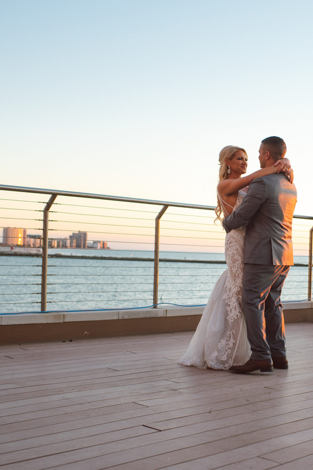 Outdoor Clearwater Beach Hotel Bride and Groom Sunset Portrait | Groom in Classic Grey Suit | Ivory Lace over Champagne Lining Sheath Fit and Flare Bridal Gown Wedding Dress by Essence of Australia