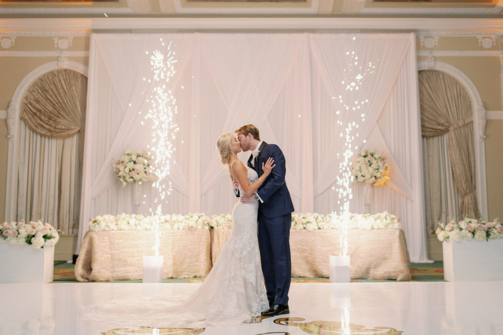 Romantic, Modern Inspired Bride and Groom Intimate Embrace and Kiss With Sparklers and Pyrotechnics at Luxurious White, Ivory, and Blush Pink Floral Decor Reception, Bride Wearing Eve of Milady Wedding Dress Tampa Bay Wedding Planner Parties A La Carte | West Central Florida Wedding Venue and Historic Resort The Renaissance Vinoy, The Grand Ballroom