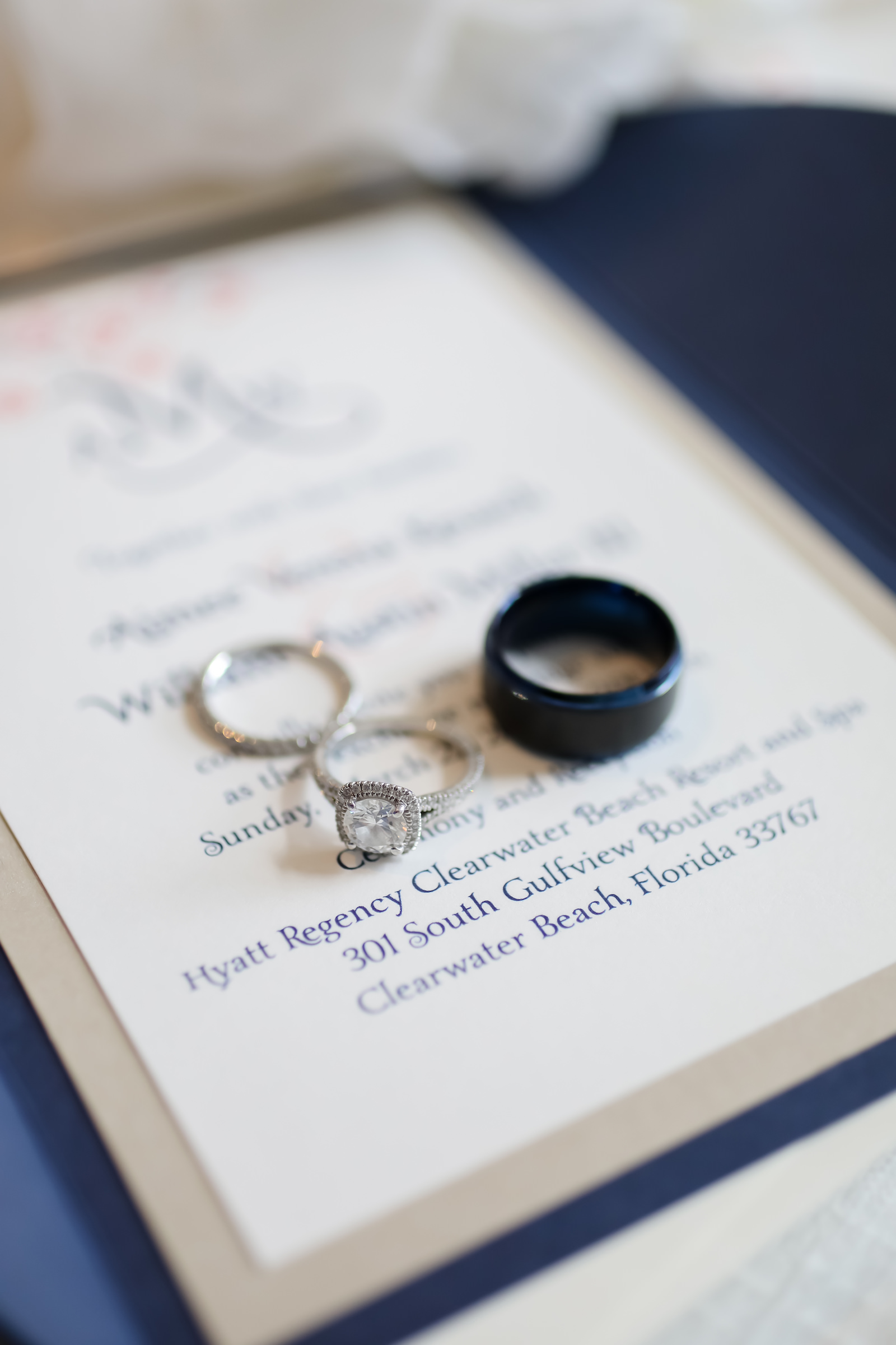 Clearwater Beach Destination Wedding Invitation with Navy and Champagne Cardstock Pocket | Wedding Rings Shot with Onyx Mens Wedding Band and Square Cushion Cut Diamond Engagement Ring with Halo and Channel Set Diamond Band