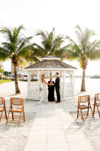Florida Bride and Groom During Intimate Vow Exchange During Beachfront Ceremony under Gazebo | Private Tampa Bay Wedding Venue Isla Del Sol Yacht and Country Club | Intimate Wedding Planner Elope Tampa Bay