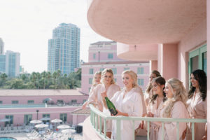Tampa Bay Bride and Bridal Party Getting Ready, Popping Champagne Before She Changes Her Last Name, Bridesmaids Wearing Matching Blush Pink Silk Robes | Florida Wedding Venue and Historic Resort The Renaissance Vinoy in Downtown St. Petersburg