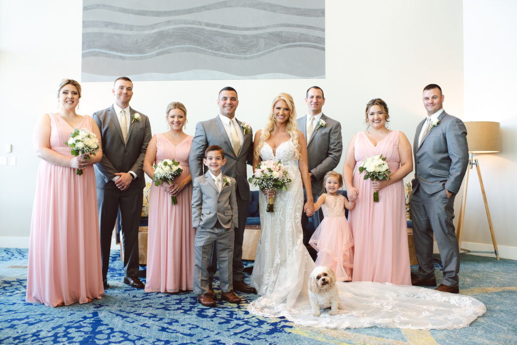 Indoor Clearwater Beach Hotel Wedding Party Portrait with Pet Dog | Groom and Groomsmen in Classic Grey Suits | Long Chiffon Blush Bridesmaid Dresses by Bella Bridesmaid | Ivory Lace over Champagne Lining Sheath Fit and Flare Bridal Gown Wedding Dress by Essence of Australia