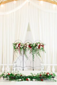 Clearwater Florida Fairy Tale Draped Wedding Ceremony Backdrop with Iron Gate Screen with Greenery Garland and Deep Dark Red Burgundy Roses with Blush Pink Roses