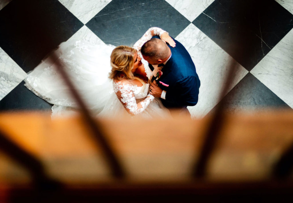 Intimate Portrait of Bride Tampa Bay Wedding Planner Katy from Coastal Coordinating and Groom on Black and White Checkered Floor | Wedding DJ Grant Hemond and Associates