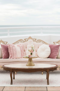 Elegant, Romantic Antique Gold and Blush Pink Velvet Couch with White and Mauve Pillows, Wooden Coffee Table with Gold Cake Stand and Three Layer Blush Pink Cake with Cascading Florals | St. Petersburg Waterfront Historic Wedding Venue The Pink Palace, Don Cesar | Tampa Bay Wedding Planner Elegant Affairs by Design | Styled Shoot | Tampa Bay Cake Company
